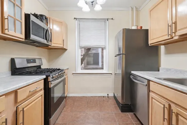 a kitchen with stainless steel appliances granite countertop a refrigerator a stove and a sink