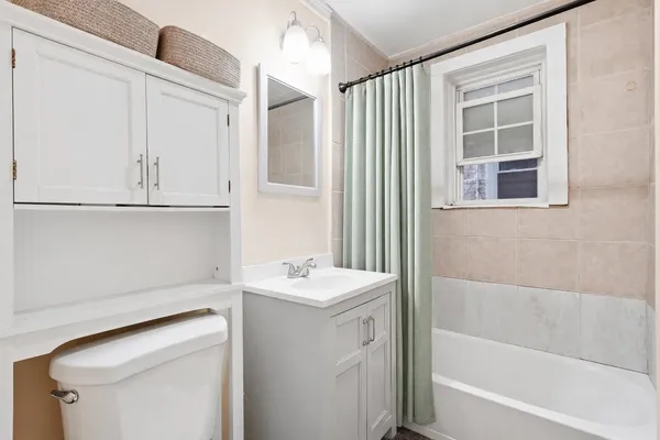 a bathroom with a bathtub sink and mirror