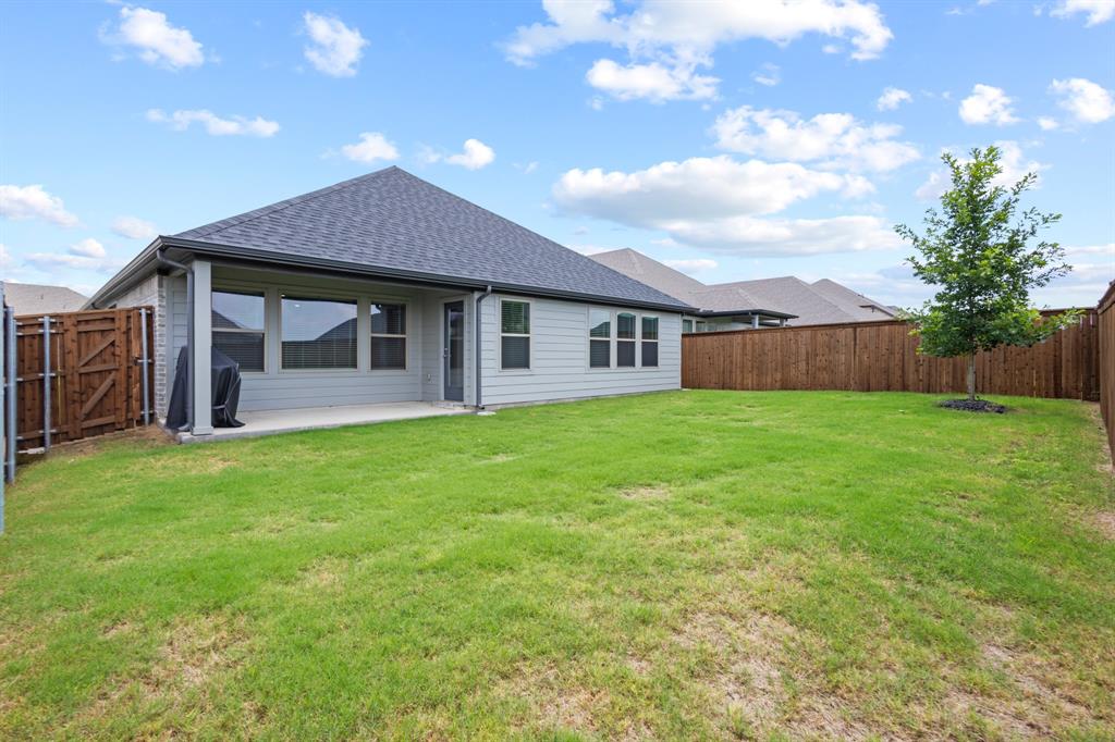 2108 Mossfield Lane Forney, TX 75126 - Photo 12 of 28 Spacious backyard featuring a large grass lawn, privacy fencing, and a concrete patio