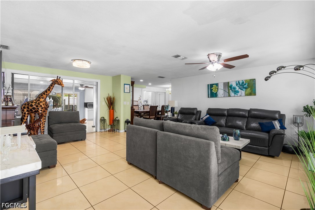 18 Illinois Road Lehigh Acres, FL 33936 - Photo 9 of 45 a living room with furniture and a chandelier