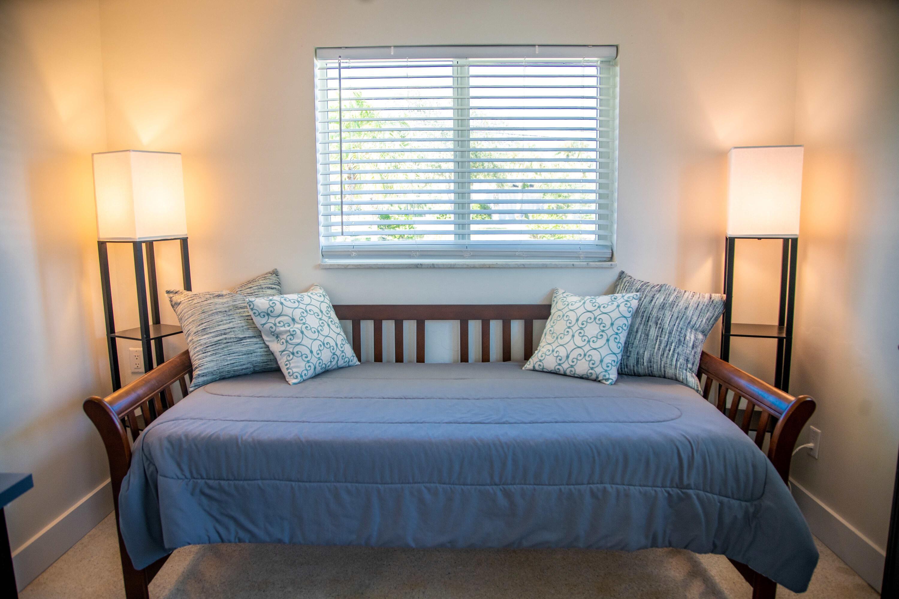 22 Van Road Jupiter, FL 33469 - Photo 19 of 38 a bedroom with a bed and a lamp