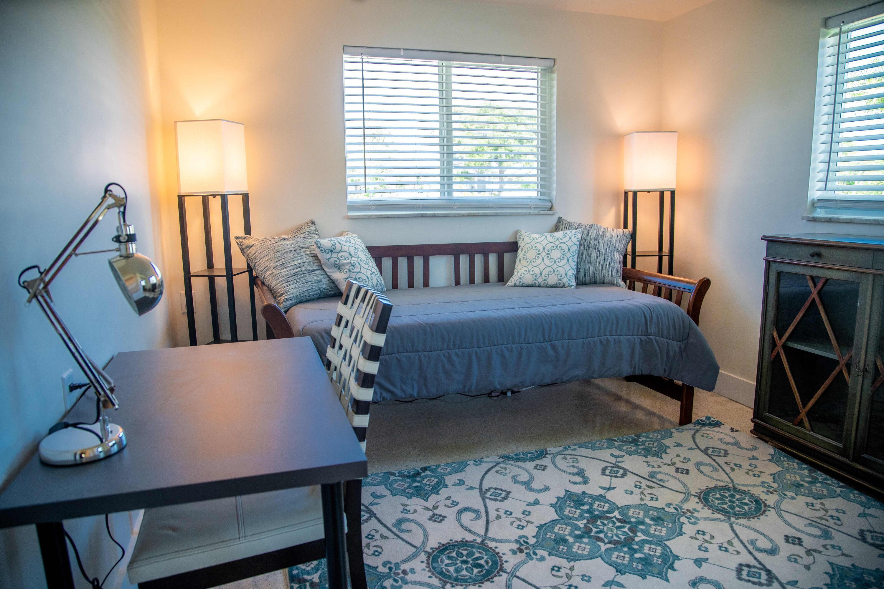 22 Van Road Jupiter, FL 33469 - Photo 20 of 38 a bedroom with a bed a desk and chair with window