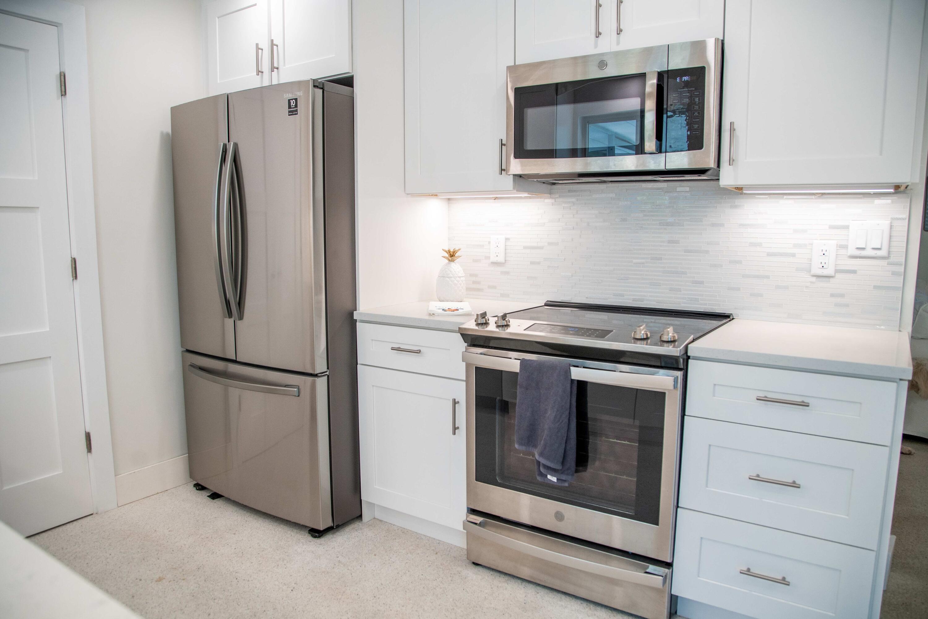 22 Van Road Jupiter, FL 33469 - Photo 25 of 38 a kitchen with stainless steel appliances white cabinets and a microwave