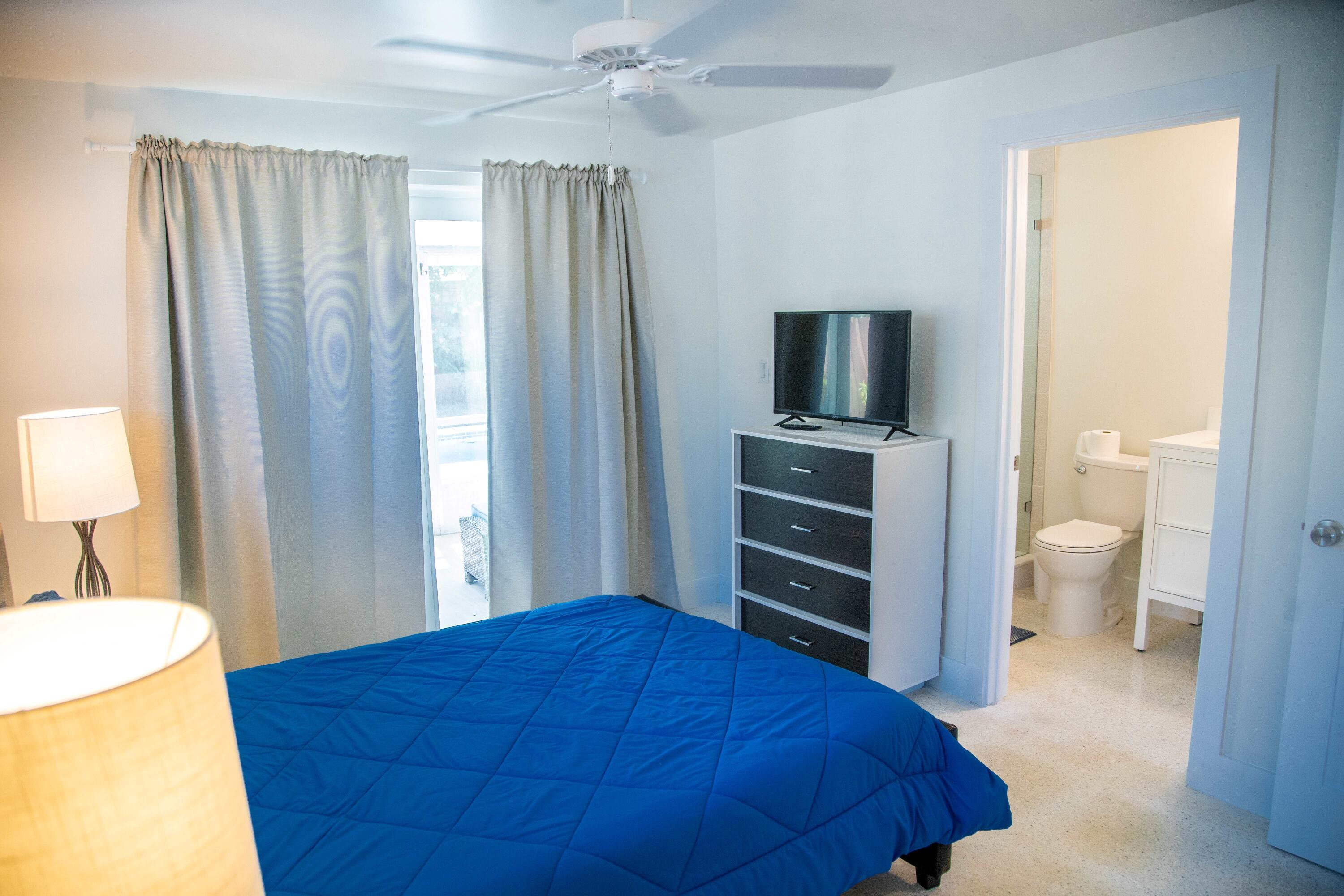 22 Van Road Jupiter, FL 33469 - Photo 3 of 38 a bedroom with a bed and a television in it