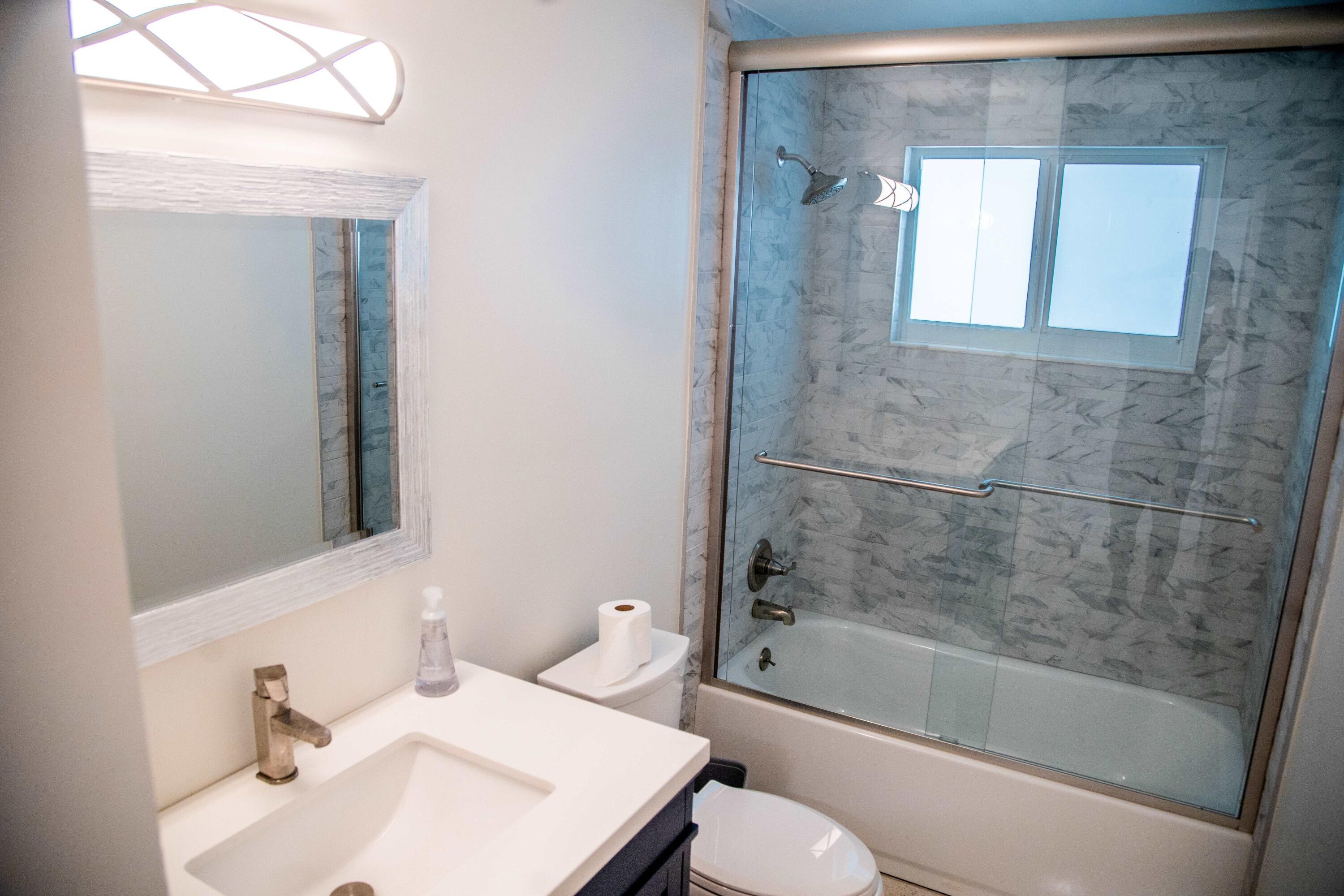 22 Van Road Jupiter, FL 33469 - Photo 8 of 38 a bathroom with a bathtub shower sink vanity and toilet