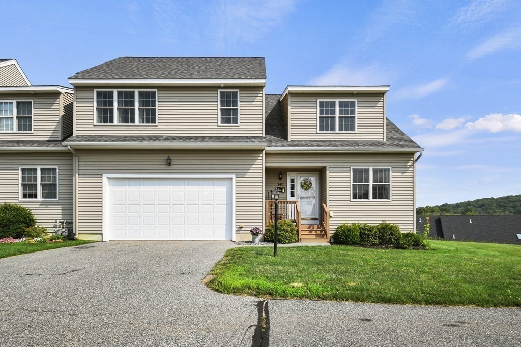 a front view of a house with a yard and garage