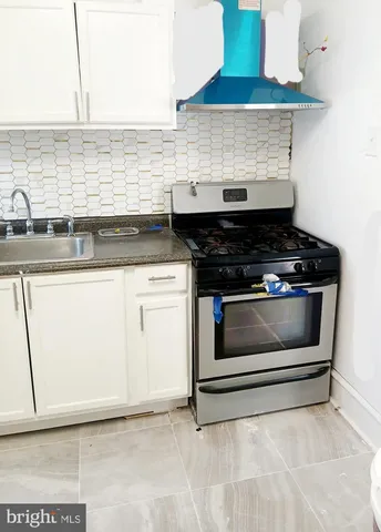 a stove top oven sitting inside of a kitchen