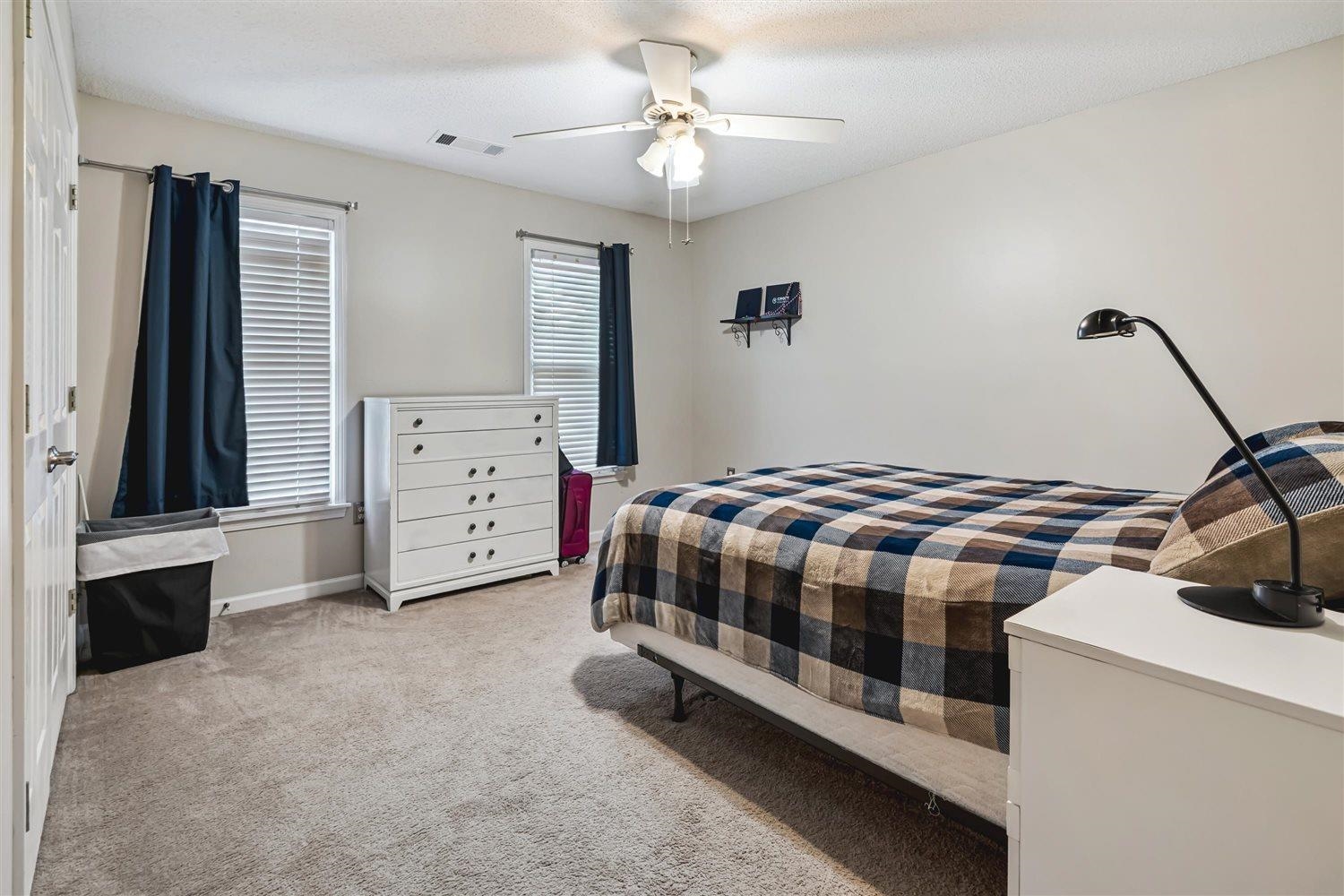 1489 John Ridge Drive Collierville, TN 38017 - Photo 32 of 39 a bedroom with a bed and a chandelier