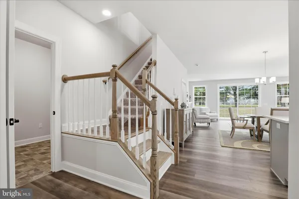 a kitchen with stainless steel appliances kitchen island granite countertop a table chairs sink and cabinets