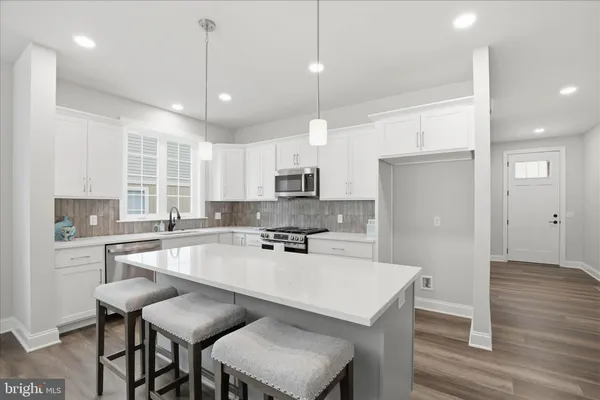 a kitchen with stainless steel appliances granite countertop a stove a sink and a microwave