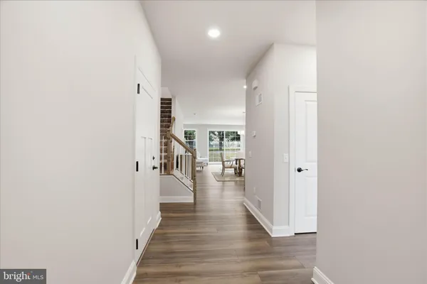 a view of a hallway with wooden floor and staircase