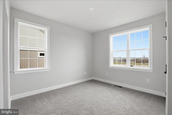 a view of an empty room with closet and a window