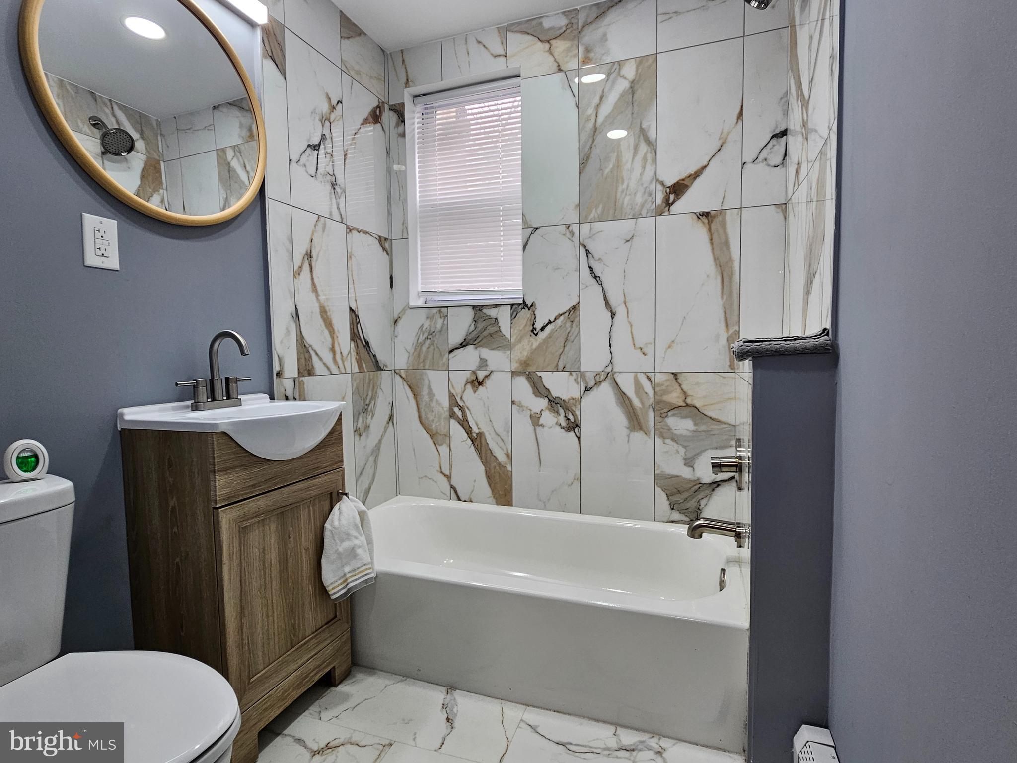 1812 North 52nd Street, Unit 1 Philadelphia, PA 19131 - Photo 9 of 9 a bathroom with a sink a toilet and a mirror