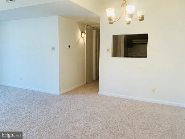 a view of a hallway with wooden floor and chandelier