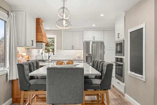 a kitchen with granite countertop white cabinets and stainless steel appliances