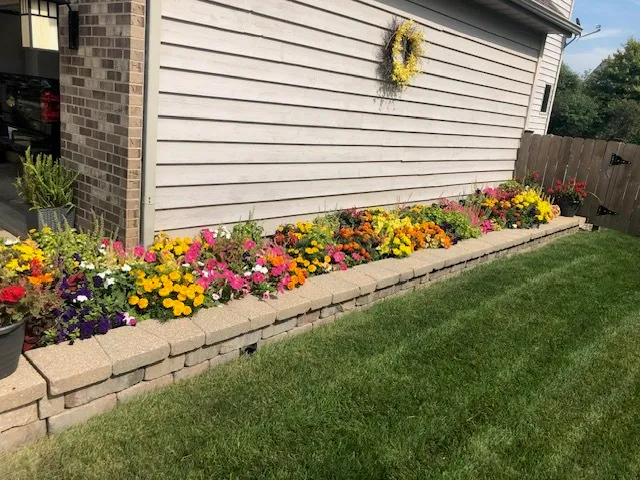 a living room with patio furniture and a potted plant