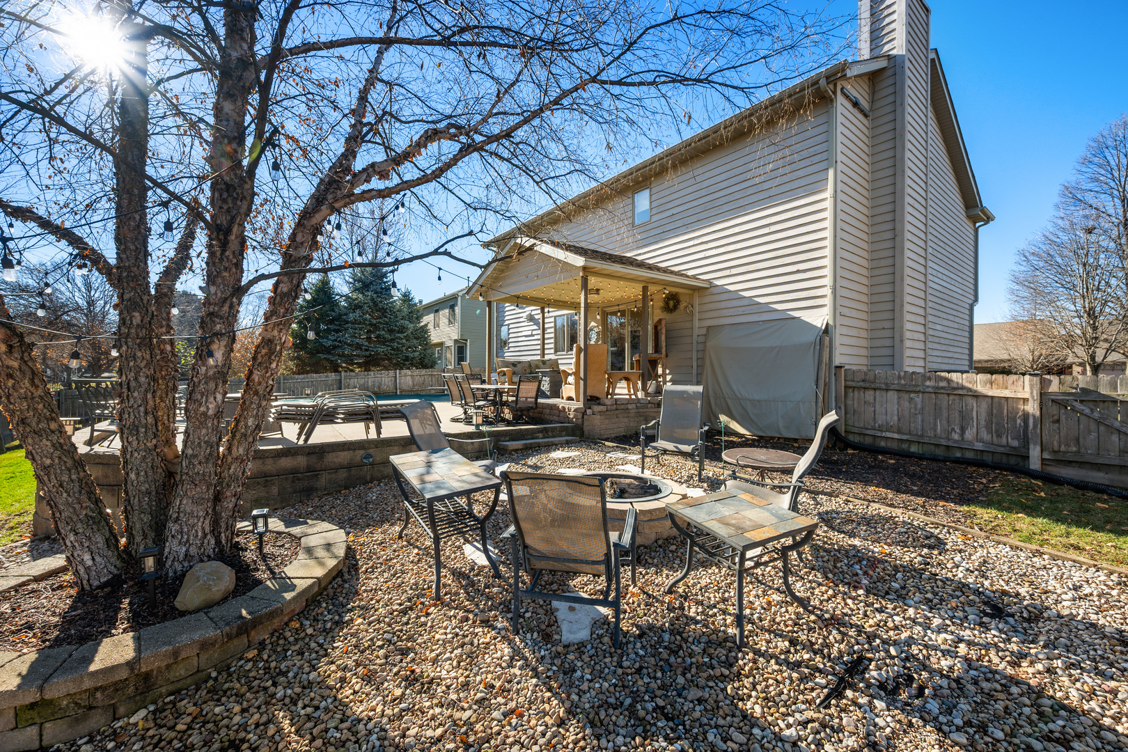 932 Foxpointe Drive Sycamore, IL 60178 - Photo 7 of 52 a view of a patio with a table and chairs under an umbrella with large trees