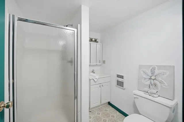 a bathroom with a shower toilet and sink
