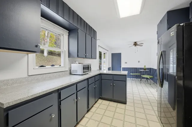 a kitchen with a sink a refrigerator and cabinets