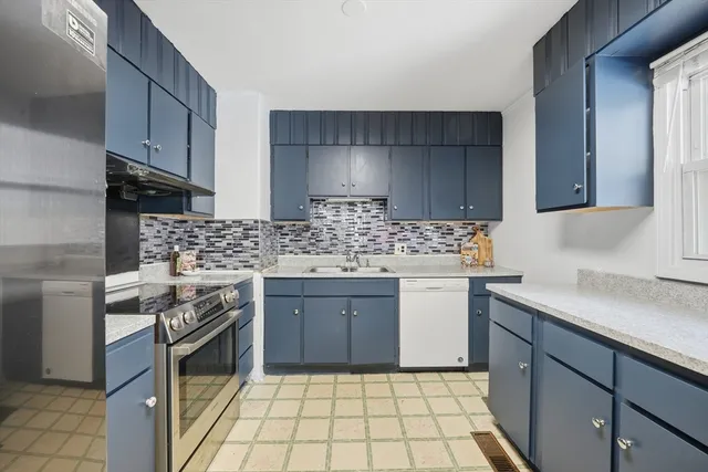a kitchen with a stove sink and cabinets