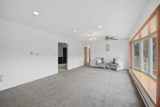 a view of an empty room with glass door and furniture