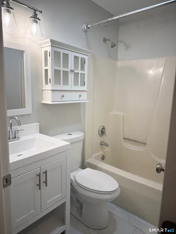 a bathroom with a sink toilet vanity and shower