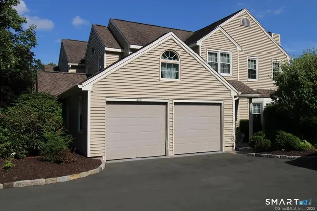 a view of a white house next to a yard