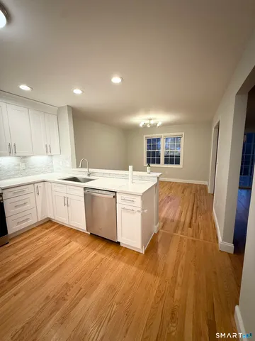 a large kitchen with a sink window and stainless steel appliances
