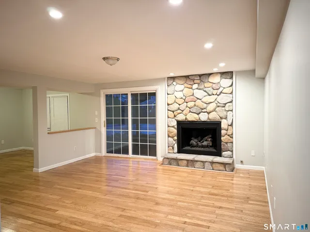 a view of an empty room with a fireplace and a window