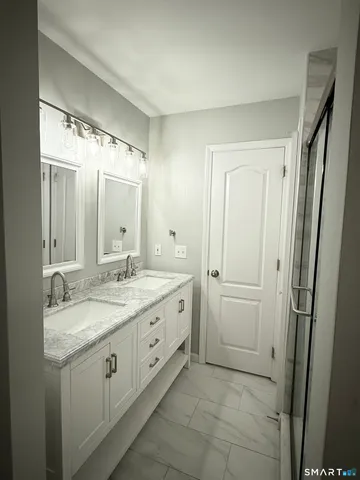 a spacious bathroom with a granite countertop sink a mirror and a