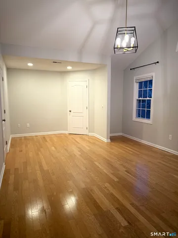 a view of empty room with wooden floor and windows