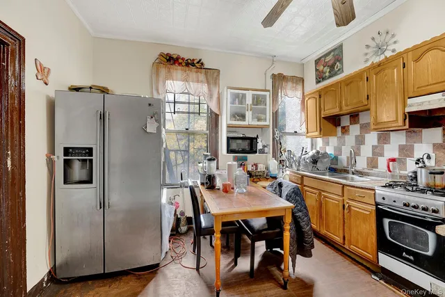 a kitchen with stainless steel appliances a stove a refrigerator and a dining table