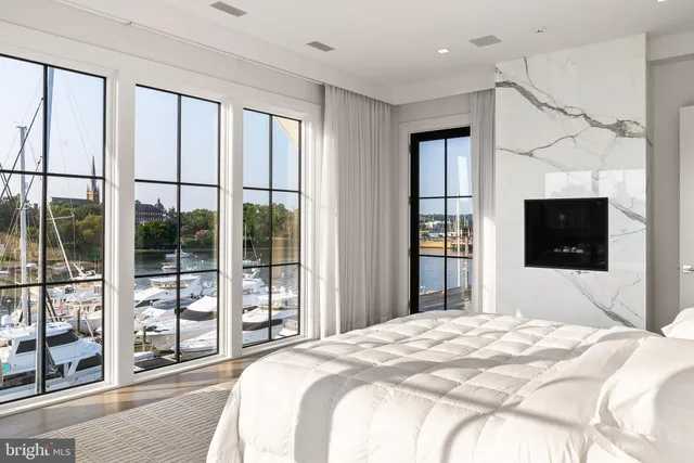 a bedroom with a large bed and a flat tv screen next to a window