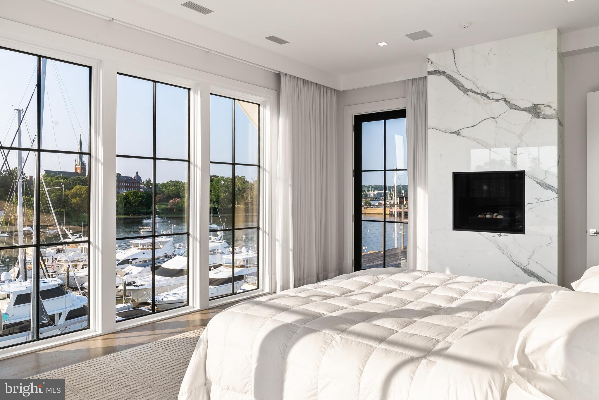 287 State Street, Unit 3 Annapolis, MD 21403 - Photo 21 of 43 a bedroom with a large bed and a flat tv screen next to a window