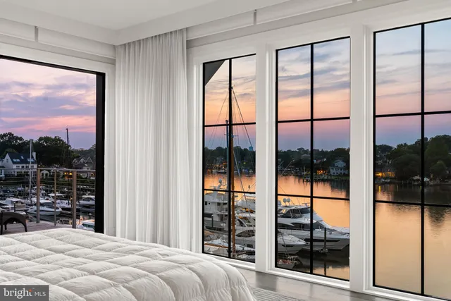 a bedroom with a large window and a balcony