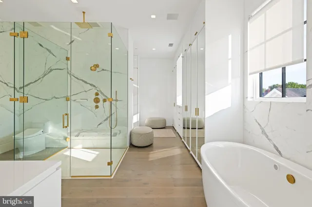 a bathroom with a tub a toilet and a shower