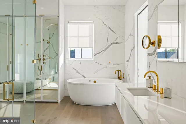 a bathroom with a white tub a mirror and a shower
