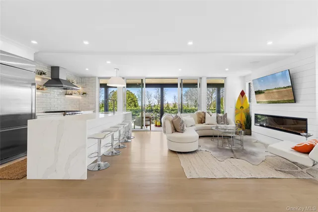 a living room with fireplace furniture and a large window