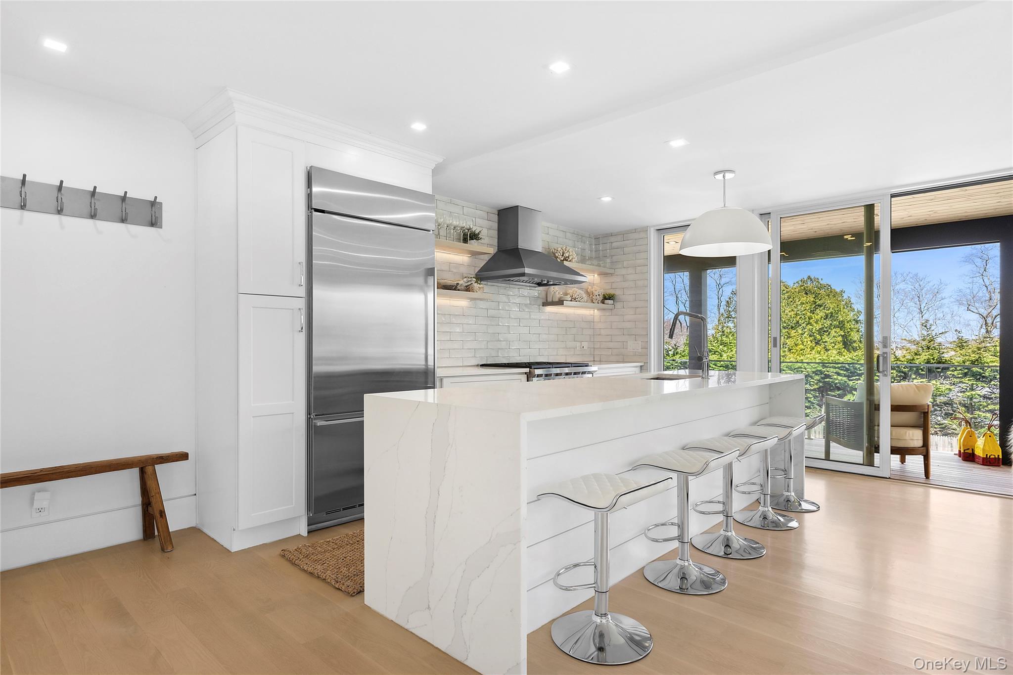 2803 Noyack Road Sag Harbor, NY 11963 - Photo 3 of 15 a room with stainless steel appliances kitchen island granite countertop a refrigerator a stove and a wooden floors