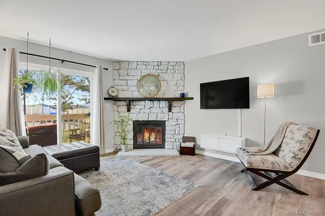a living room with furniture a flat screen tv and a fireplace