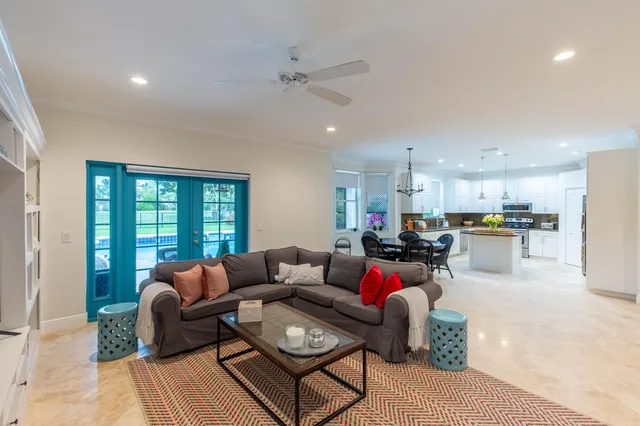 a living room with furniture kitchen view and a window