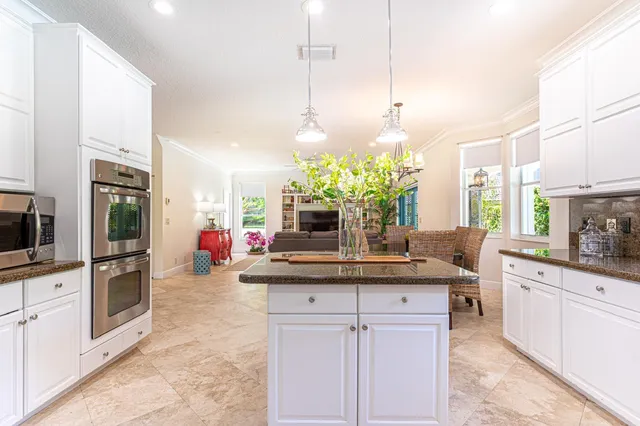 a kitchen with kitchen island granite countertop a sink a counter top space appliances and cabinets