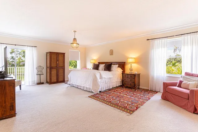a spacious bedroom with a bed and glass windows