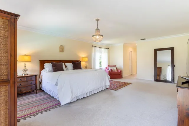a spacious bedroom with a bed and a chandelier