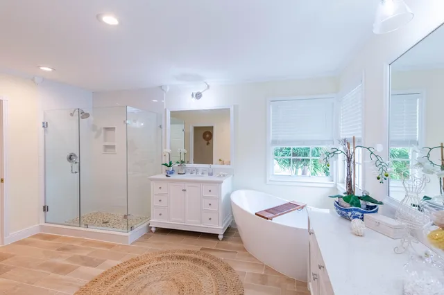 a living room with a balcony a bed and a potted plant