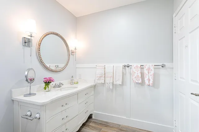 a bathroom with a sink vanity mirror and toilet