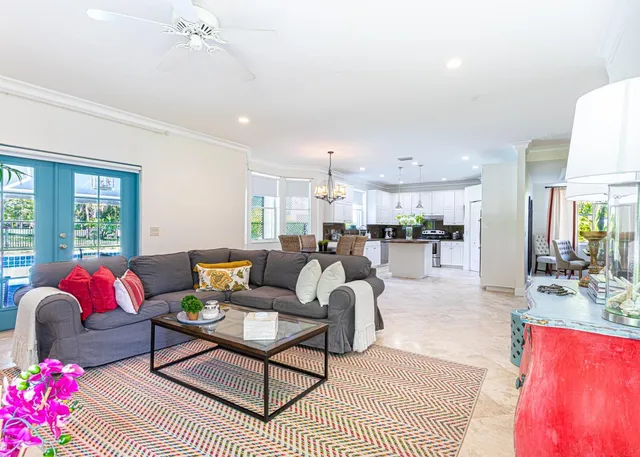 a living room with furniture a rug kitchen view and a large window