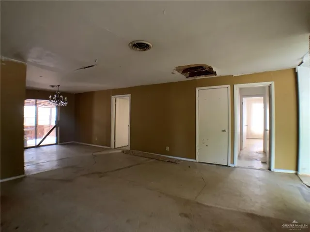 an empty room with closet and windows