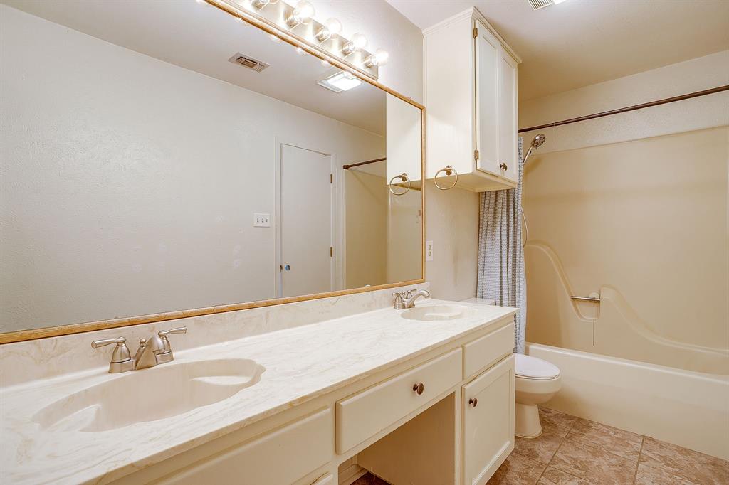 709 North Ave B Springtown, TX 76082 - Photo 27 of 32 a bathroom with a granite countertop sink toilet and shower