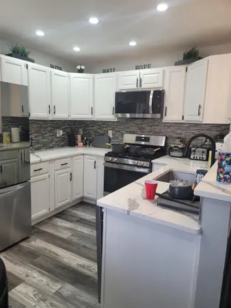 a kitchen with stainless steel appliances kitchen island granite countertop a sink stove and cabinets